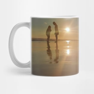 Silhouetted people in a row on a sand beach. Mug